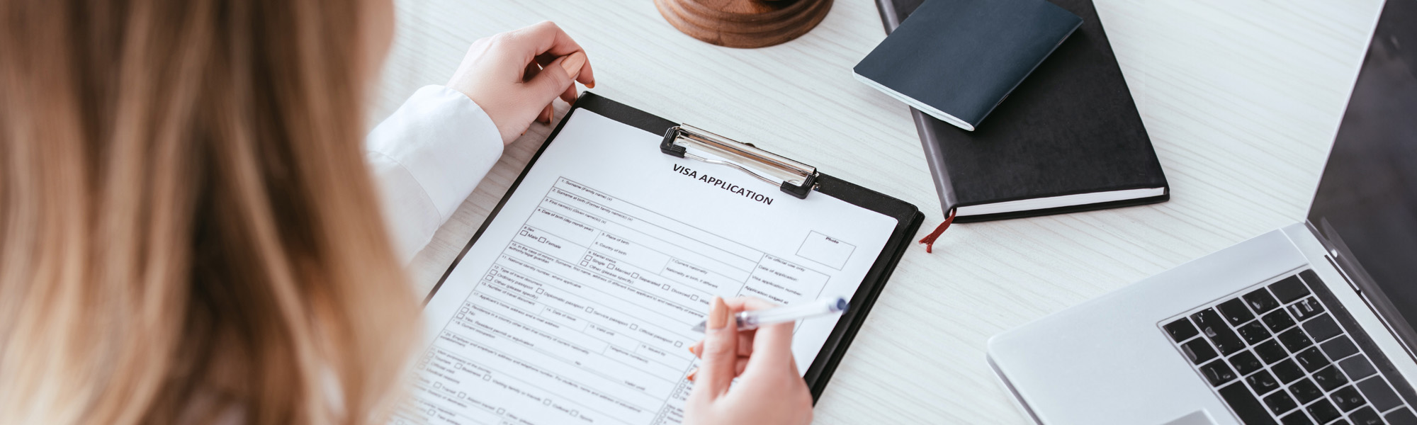 woman holding pen near document with visa application image