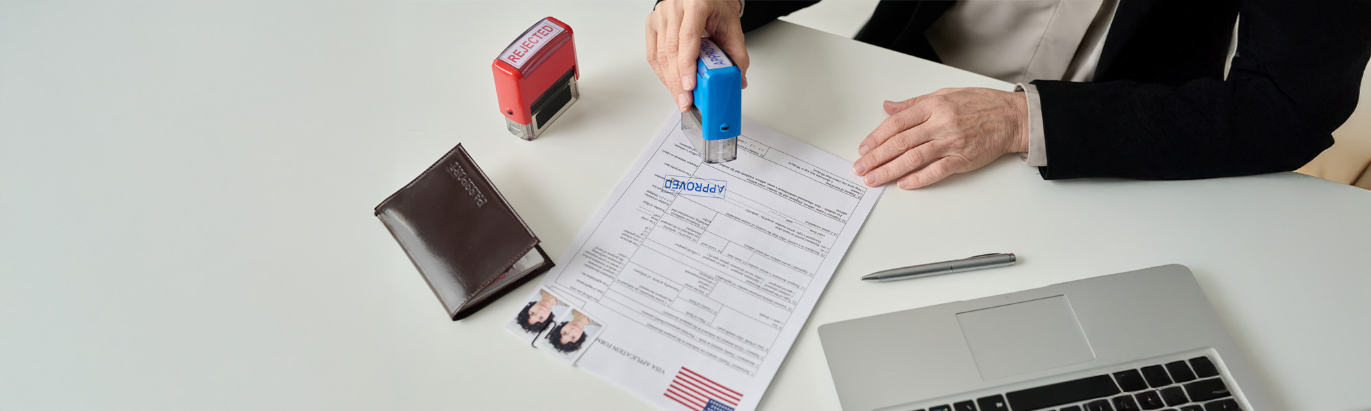 worker putting approved stamp on visa application image